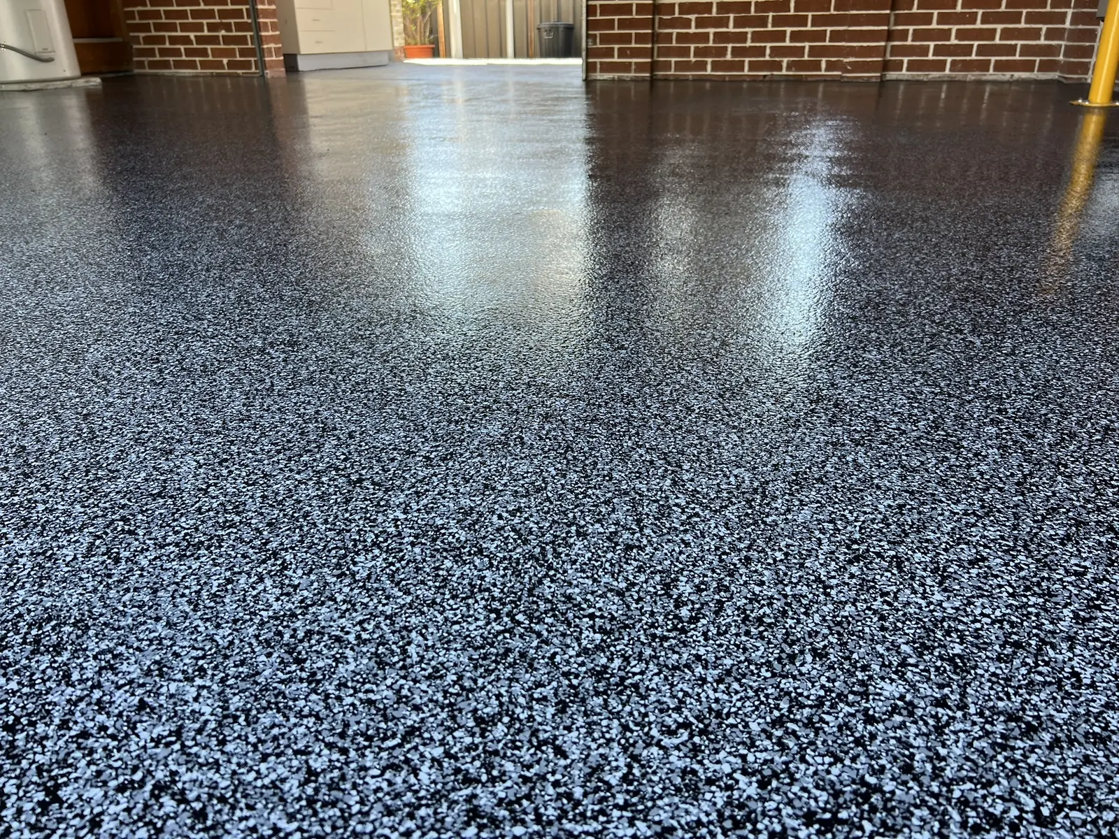 Black decorative flake garage floor with a seamless gloss finish