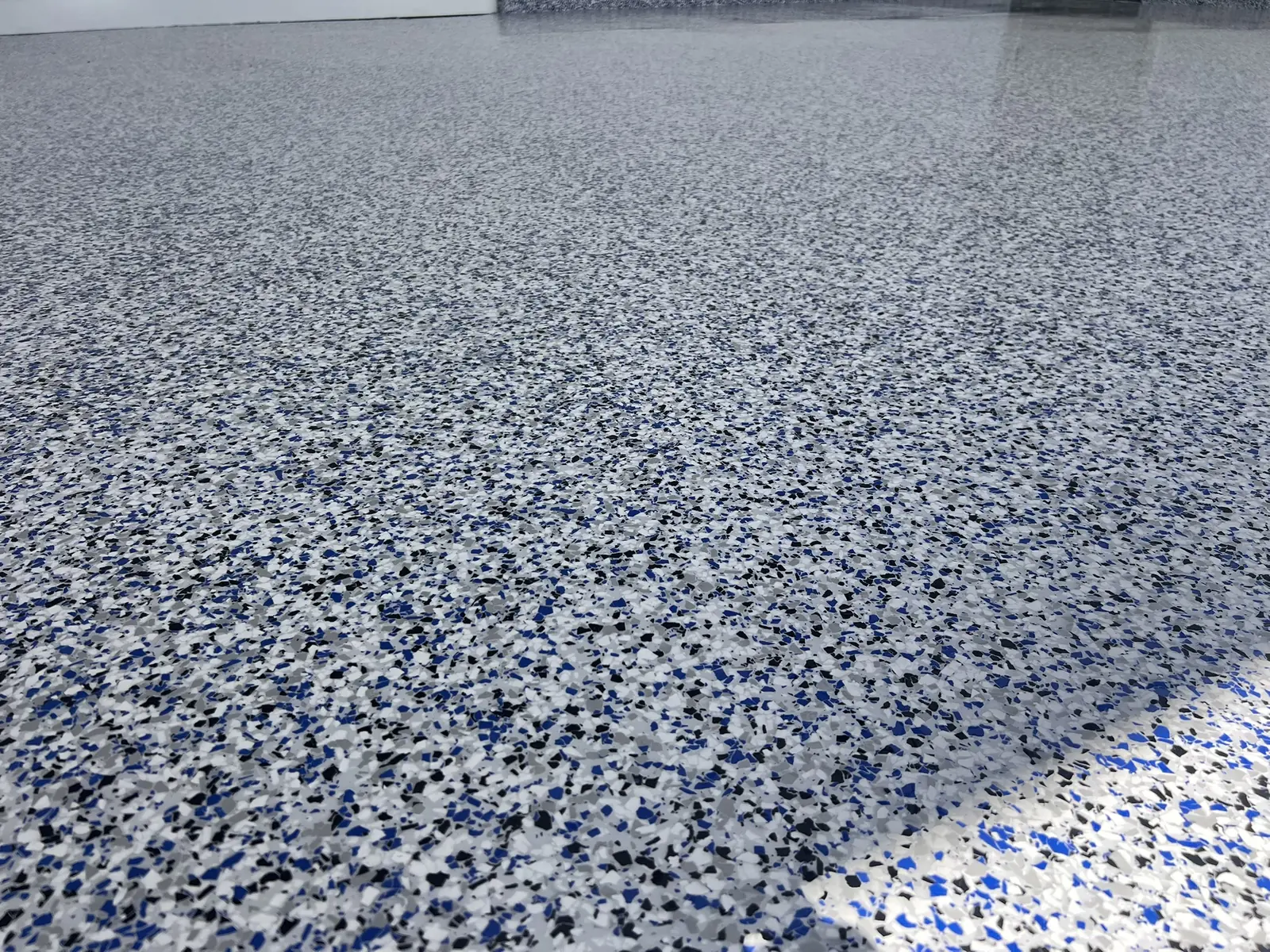 Wide view of a blue and grey decorative flake garage floor