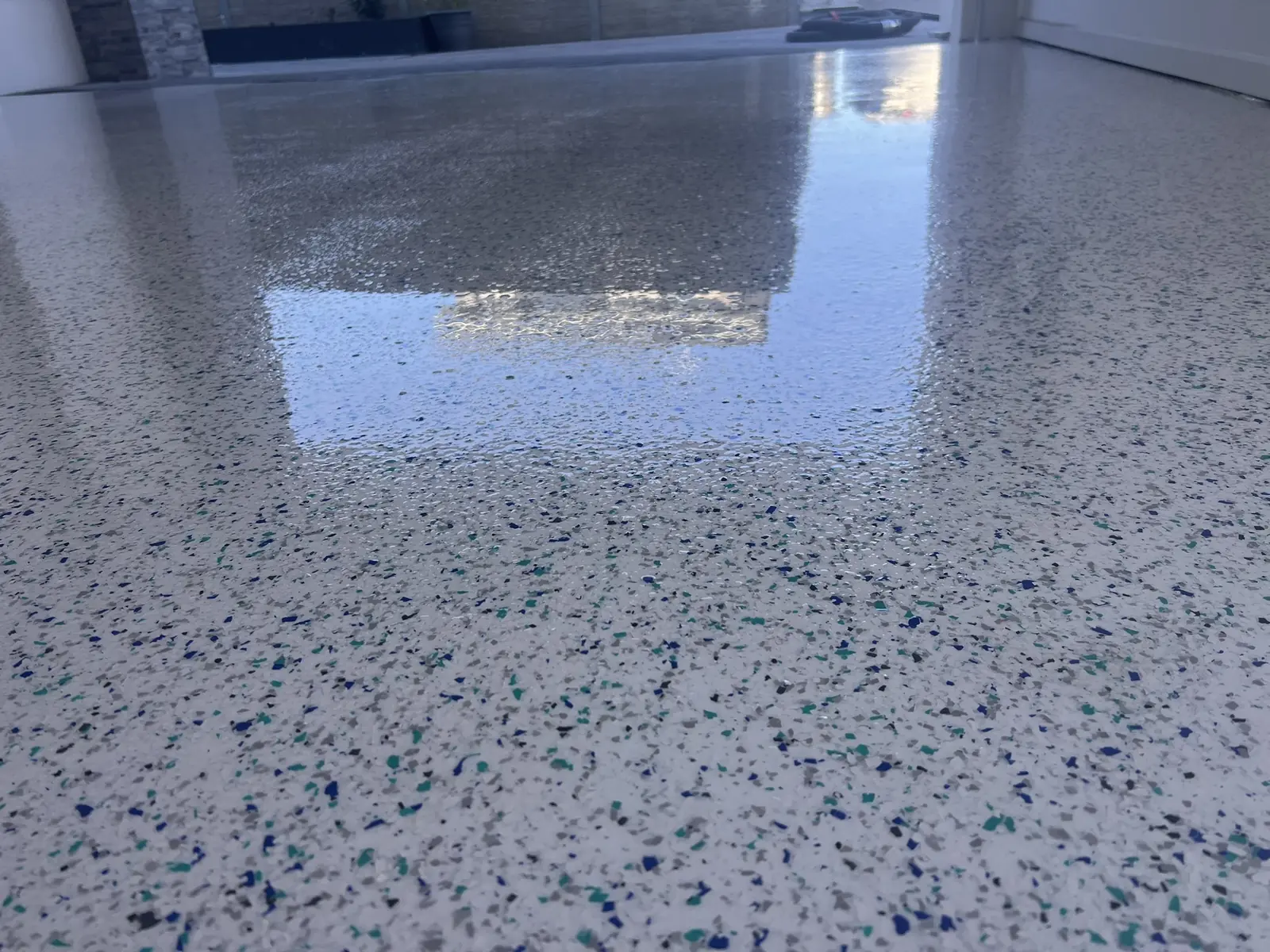 Blue and teal decorative flake garage floor with reflective finish