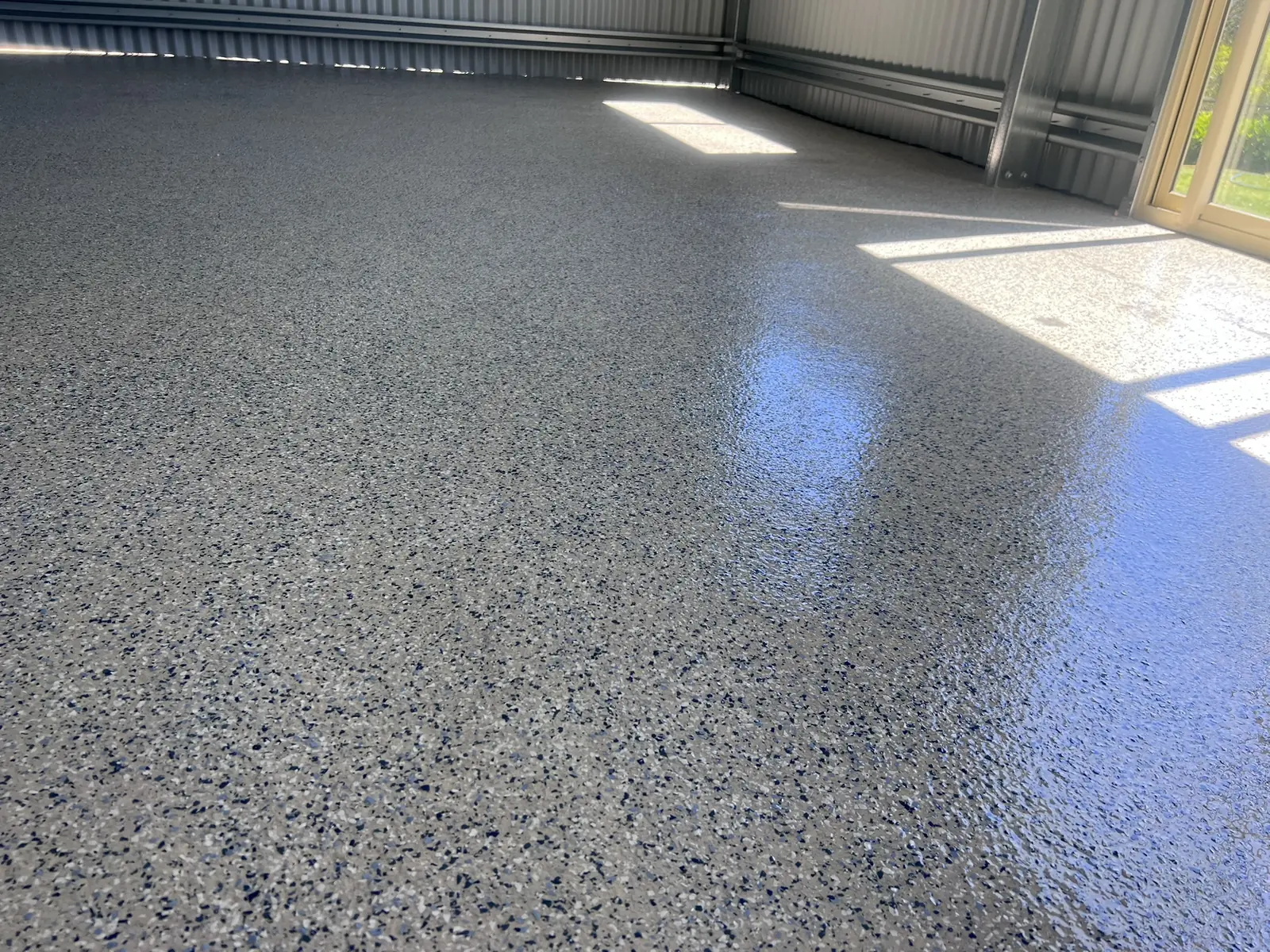 Grey decorative flake coating across a residential garage floor
