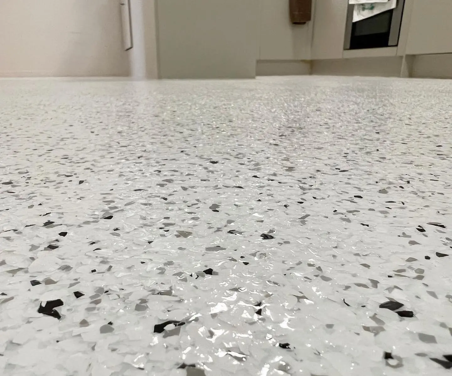 Light grey, white and black decorative flake garage floor detail