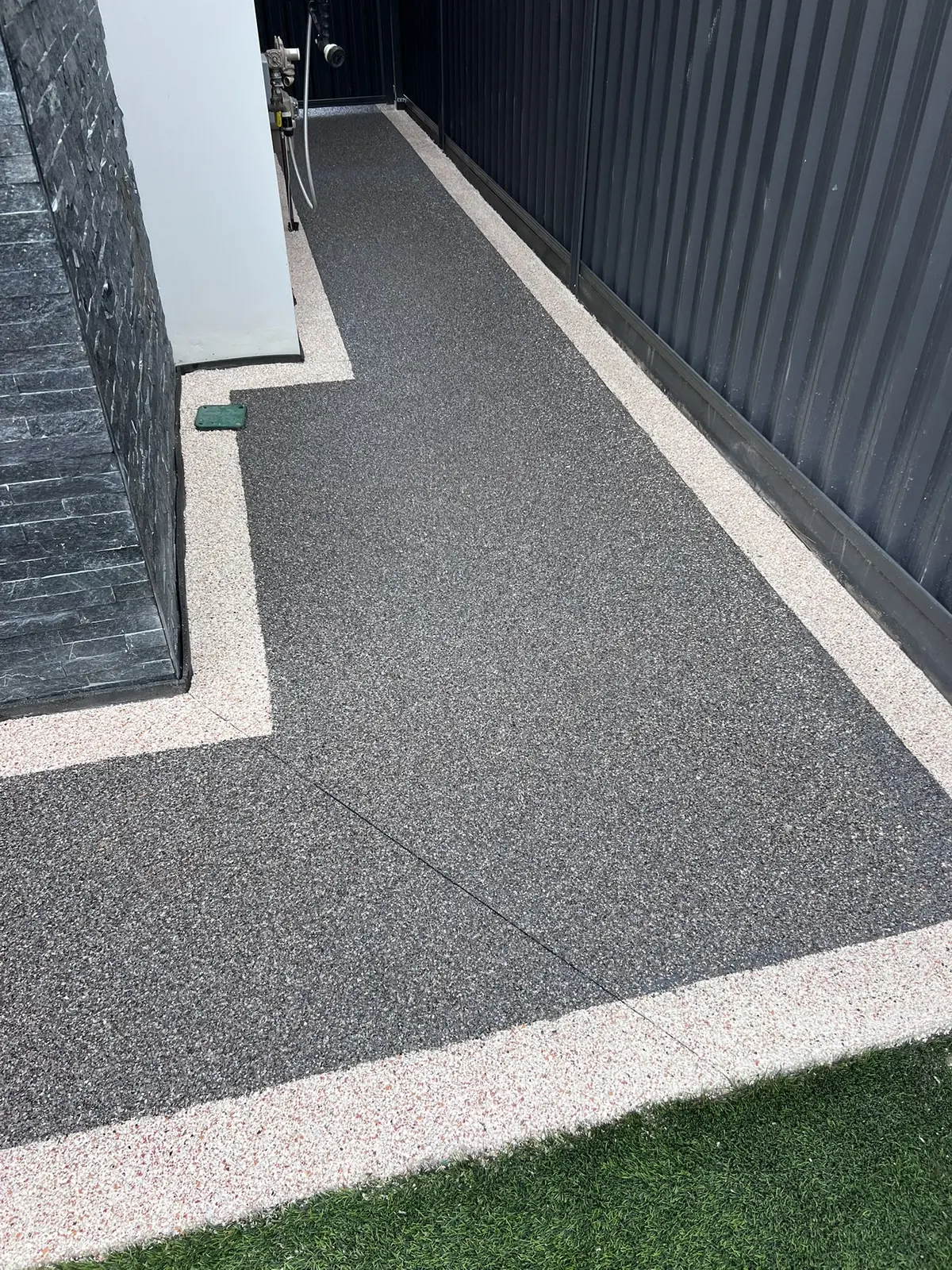 Two-tone decorative flake coating at a garage-side access area