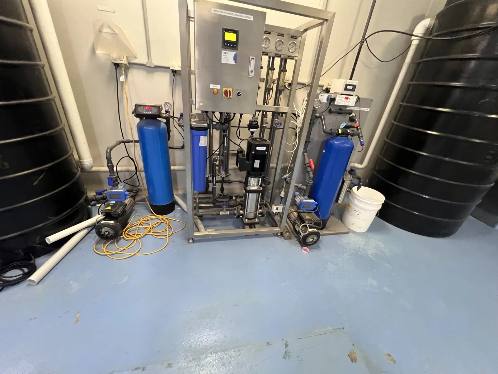 Pharmaceutical equipment area with worn blue floor before coating works