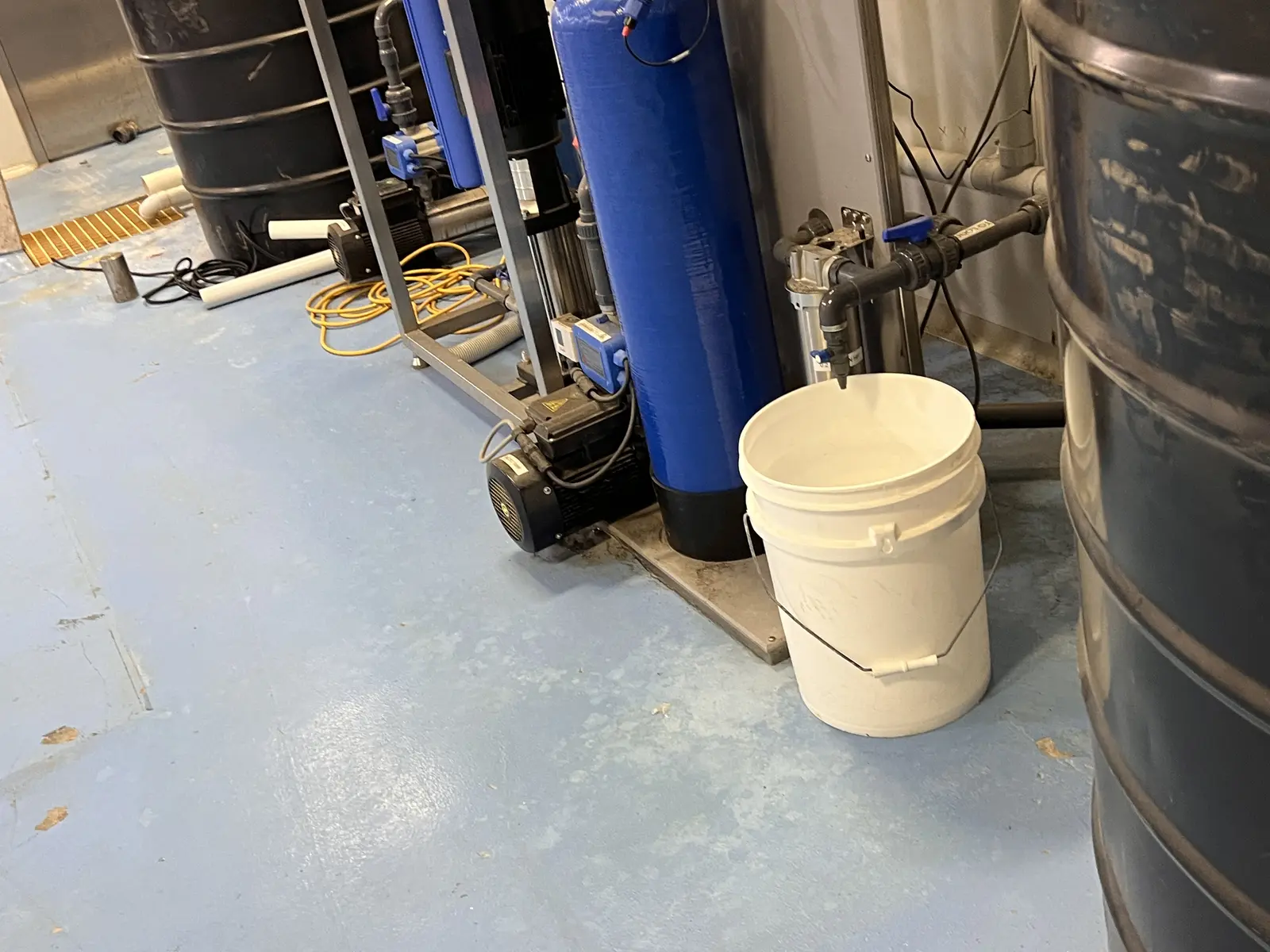 Old epoxy floor around tanks and equipment before preparation